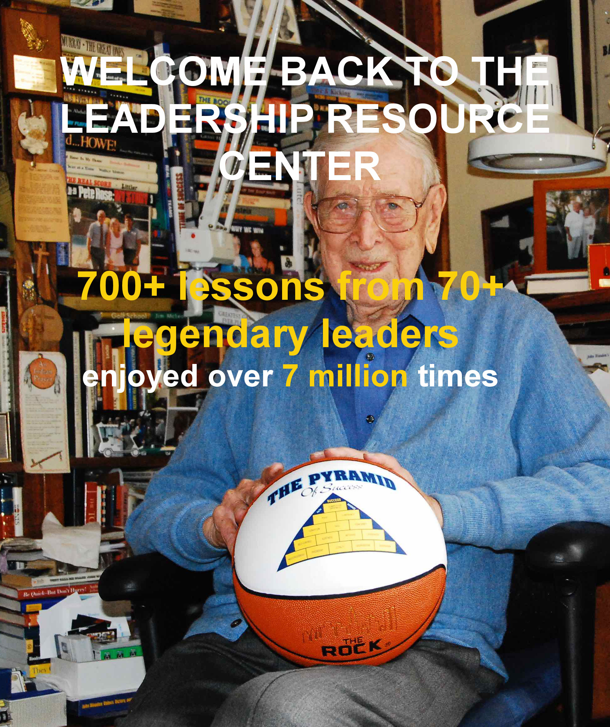 Coach Wooden iholding a basketball with his 'Pyramid of Success' printed on the ball.